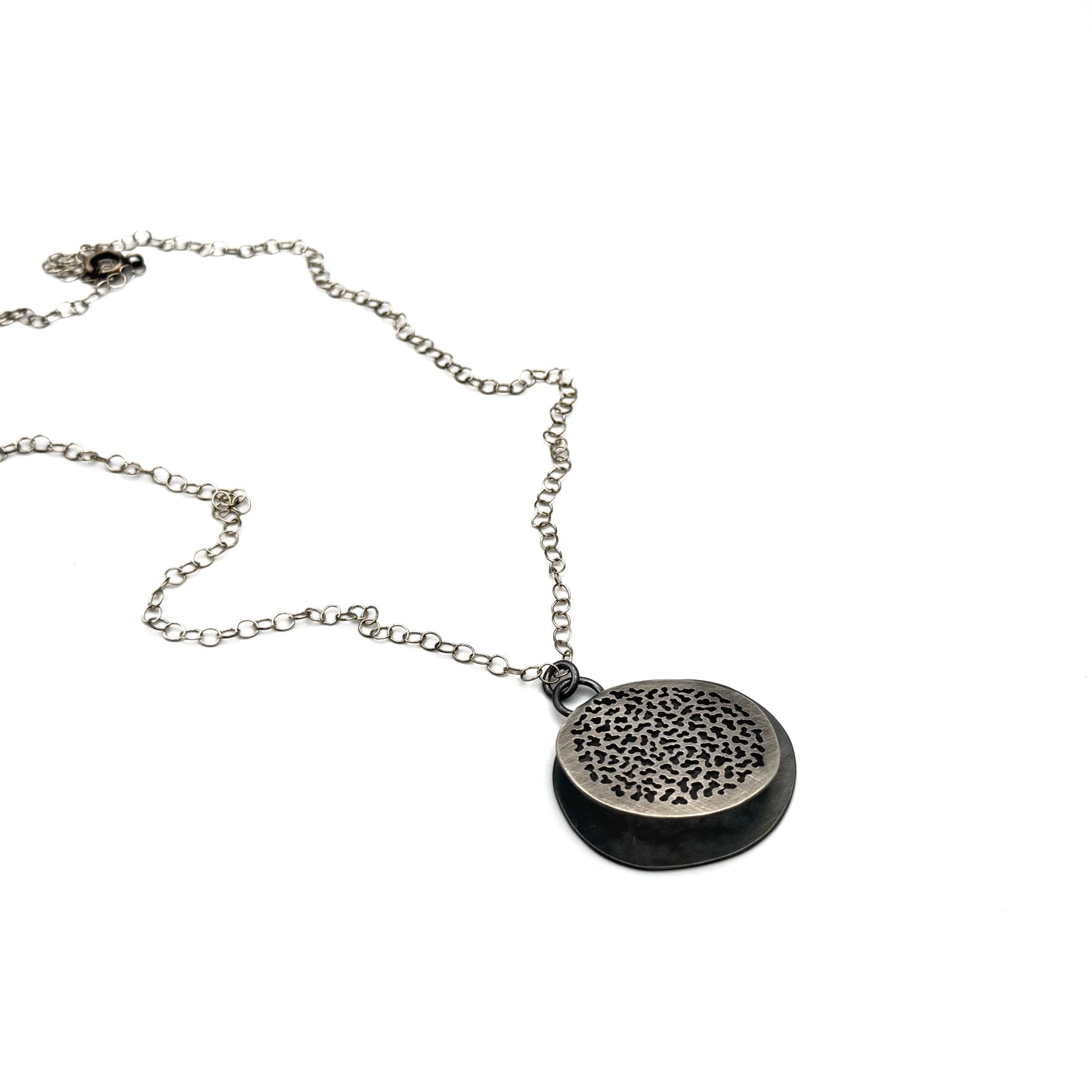 Hand pierced oxidize, silver pendant.