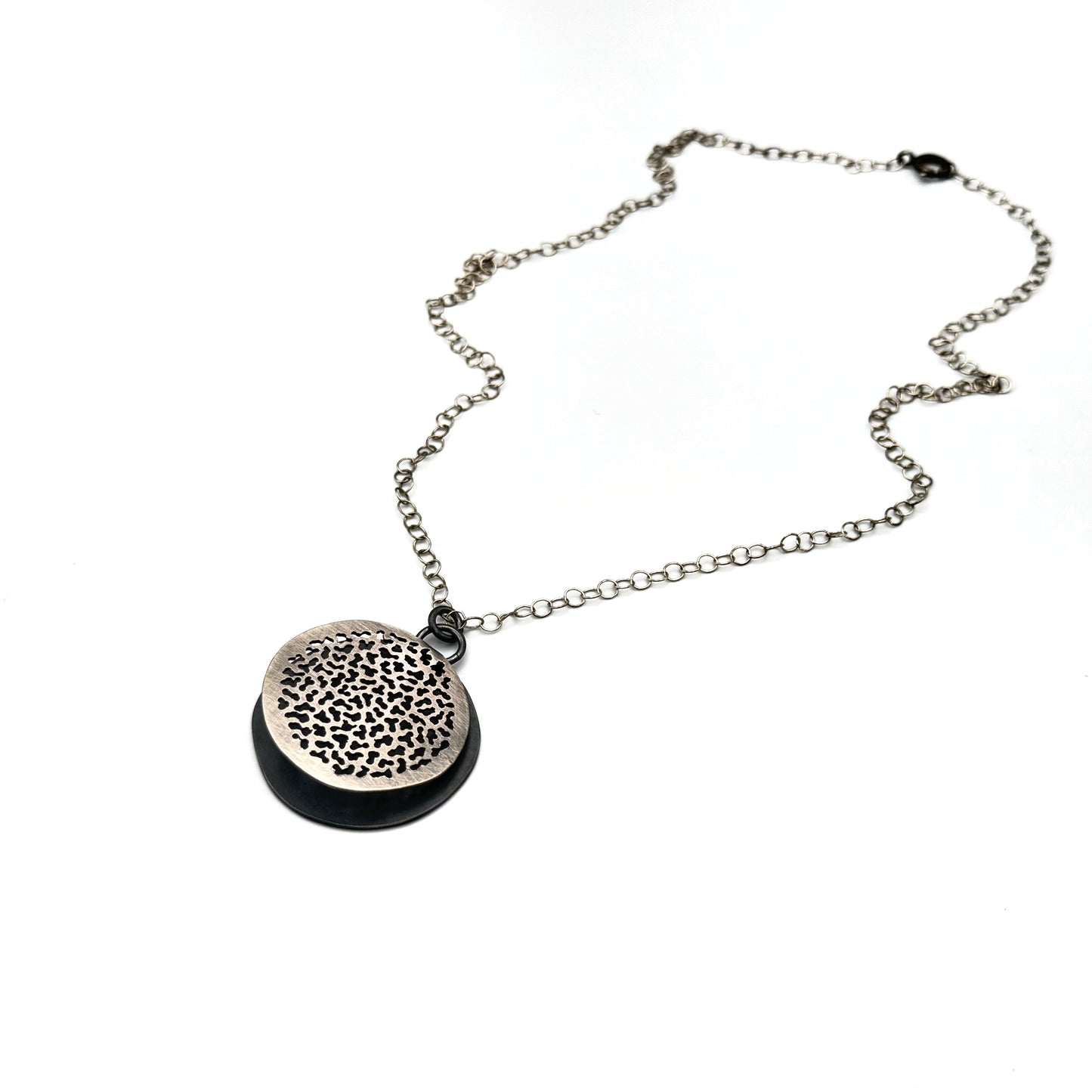 Hand pierced oxidize, silver pendant.
