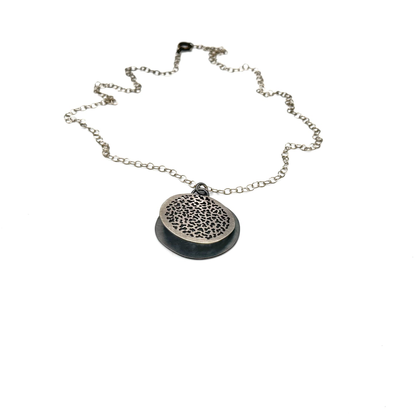 Hand pierced oxidize, silver pendant.