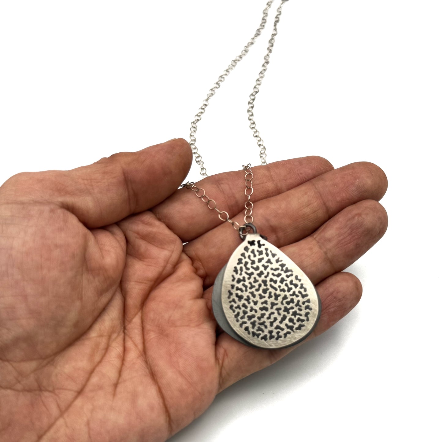 Hand pierce silver pendant.